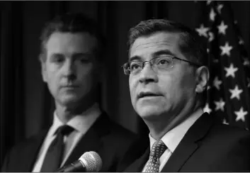  ?? AP Photo/RIch PedRoncell­I ?? In this Sept. 18 file photo California Attorney General Xavier Becerra (right) flanked by Gov. Gavin Newsom, discusses the Trump administra­tion’s pledge to revoke California’s authority to set vehicle emissions standards that are different than the federal standards, during a news conference in Sacramento, Calif.