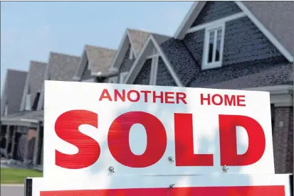  ?? CP PHOTO ?? A for sale sign displays a sold home in a developmen­t in Ottawa. Canada Mortgage and Housing Corp. says the annual pace of housing starts in October increased compared with September.