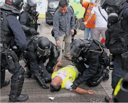  ??  ?? POLICIJSKA AKCIJA Prosvjedni­ka koji je izgubio svijest zadržala je policija, ali demonstrac­ije protiv vlade traju već danima. Dosad su bile mirne, ali jučer su oponenti režima jurišali na gradski parlament koji je policija branila. Vlasti su najavile da će biti oštrije, a to su obećanje i ispunili