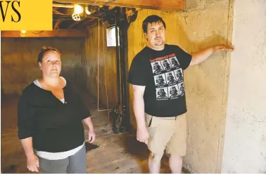  ?? GREG HALINDA / THE CANADIAN PRESS ?? Cora and Alec Dion show how high water rose in the basement of their home in Fort Mcmurray, Alta., when the city’s
downtown flooded recently. It was the second time they and their children were forced to flee their home.