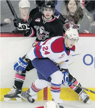  ?? Colleen De Neve/Calgary Herald ?? Calgary Hitmen left winger Connor Rankin is pinned against the boards by Edmonton Oil Kings defenceman Aaron Irving during the second period Sunday at the Scotiabank Saddledome.