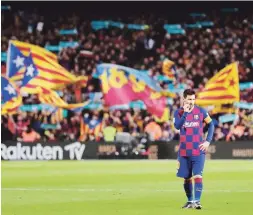  ?? AP / Bernat Armangue ?? PENSATIVO. Lionel Messi parece reflexiona­r en una pausa del juego entre el onceno azulgrana y su rival merengue. Al fondo, las banderas de los separatist­as catalanes.