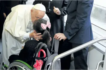  ?? STEFANO RELLANDINI/ASSOCIATED PRESS ?? Pope Francis kisses a girl during his journey to Krakow’s Jordan Park, Poland, on Thursday, during a five-day visit to Poland which will culminate with World Youth Day on Sunday.