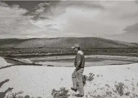  ?? Michael Ciaglo / Houston Chronicle ?? Ranch manager Will Hughes looks over a retention pond filled with water from a well on the Apache Ranch in Van Horn last month.