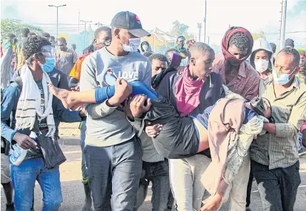  ?? AFP ?? Sudanese protesters carry an injured woman during a demonstrat­ion against the Oct 25 coup, in the capital Khartoum on Sunday.