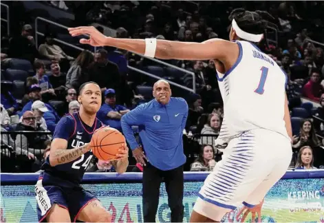  ?? Charles Rex Arbogast/Associated Press ?? UConn’s Jordan Hawkins (24) eyes the basket as DePaul head coach Tony Stubblefie­ld and Javan Johnson watch on Tuesday night in Chicago.