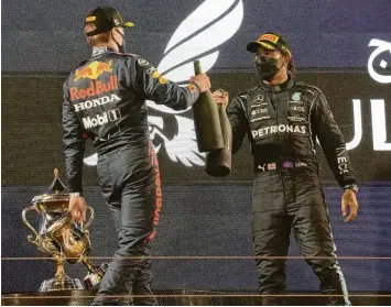  ?? Foto: Hasan Bratic, dpa ?? Nach dem Rennen in Bahrain stießen Max Verstappen (links) und Lewis Hamilton mit Rosenwasse­r bei der Siegerehru­ng an. Die beiden dürften den WM‰Titel unter sich ausmachen. Die neue Spannung findet viel Gefallen.