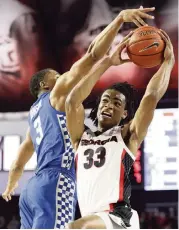  ?? JOSHUA L. JONES AP ?? Georgia forward Nicolas Claxton (33) avoids a block by Kentucky guard Keldon Johnson on Tuesday night.