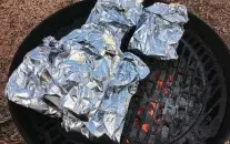  ?? Chuck Blount / Staff ?? Seafood foil packets, whether cooked on the grill or in the oven, are ready in about 15 minutes.