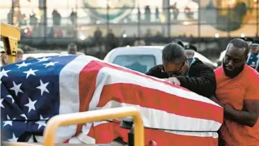  ?? KENNETH K. LAM/BALTIMORE SUN ?? Parents Tina and Carlos Lacy touch the casket containing their son Makai Cummings, a USAF airman who was killed in a hit-andrun crash in Virginia last week.