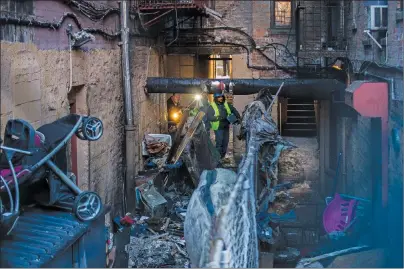  ?? AP PHOTO ?? Police and workers inspect the building Friday, where more than 10 people died in a fire in the Bronx borough of New York. New York City’s deadliest residentia­l fire in decades was accidental­ly lit by a boy playing with the burners on his mother’s...