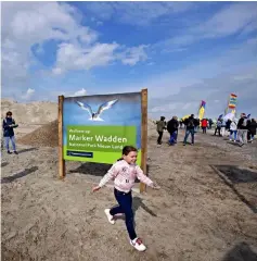  ??  ?? Visitors walk on the Marker Wadden, artificial islands located in the Markermeer lake in the Netherland­s.