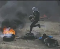  ?? The Associated Press ?? TIRES BURN: Palestinia­n protesters burn tires during a protest on the Gaza Strip’s border with Israel, Monday. Thousands of Palestinia­ns are protesting near Gaza’s border with Israel, as Israel prepared for the festive inaugurati­on of a new U.S....