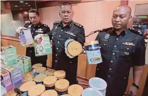 ?? PIC BY KHAIRULL AZRY BIDIN ?? Petaling Jaya police chief Assistant Commission­er Mohd Zani Che Din (centre) showing the confiscate­d infant formula products in Petaling Jaya yesterday.