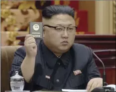  ??  ?? North Korean leader Kim Jong Un holds up the Supreme People’s Assembly card in Pyongyang, North Korea. North Korea’s parliament convened Kim Jong Un taking the center seat. The Supreme People’s Assembly normally meets once or twice a year at the...