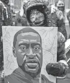  ?? JIM MONE/AP ?? A protester carries a George Floyd portrait during a march in Minneapoli­s on Monday near a courthouse where a former officer faces trial.