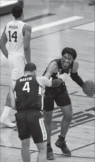  ?? KATHY WILLENS/AP PHOTO ?? Connecticu­t forward Isaiah Whaley (5) congratula­tes guard Tyrese Martin (4) after the Huskies defeated Seton Hall 69-58 on Wednesday night in Newark, N.J.