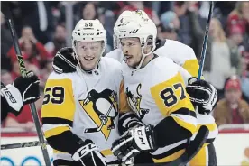  ?? BRUCE BENNETT GETTY IMAGES ?? Penguin Jake Guentzel (59) celebrates his game-winning goal with Sidney Crosby.