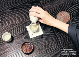  ??  ?? A Geisha pours sake at a traditiona­l restaurant in Tokyo.