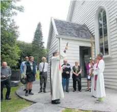  ?? Photo / Sandy Myhre ?? Archdeacon Jonathan Gale (left) conducting the ancient “clypping” ceremony at Christ Church in Russell. Reverend Chris Swannell (right) assists.