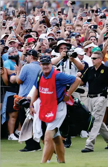  ??  ?? Tiger Woods is backed by an army of fans as he heads down the 18th fairway