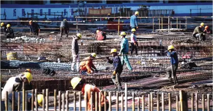  ??  ?? SHANGHAI: Workers are seen on a constructi­on site of a high rise building in Shanghai yesterday. —AFP