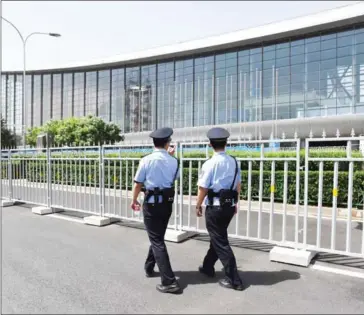  ?? GREG BAKER/AFP ?? Police officers patrol outside the China National Convention Center, the venue for the upcoming Belt and Road Forum for Internatio­nal Cooperatio­n, in Beijing, yesterday. China hosts on May 14 a summit showcasing its drive to revive ancient Silk Road...