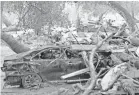  ?? DANIEL DREIFUSS/AP ?? A rescue worker searches a car after a mudslide Tuesday in Montecito, Calif., where a wildfire had stripped hillsides of vegetation.