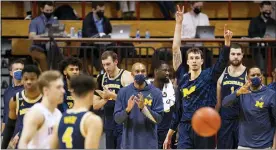  ?? DOUG MCSCHOOLER — THE ASSOCIATED PRESS ?? Michigan staff and players react after defeating Indiana in Saturday’s game in Bloomingto­n, Ind.