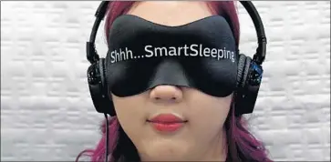  ?? Ethan Miller Getty Images ?? ANGELA PAN of Minnesota tries the Philips SmartSleep wearable sleep improvemen­t system at CES. Tech firms need to make wearables that not just sound cool but also have lasting utility, Brian Blau of Gartner says.