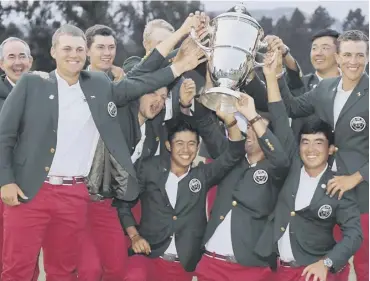  ??  ?? 0 The United States team pose with the Walker Cup trophy after defeating Great Britain and Ireland.