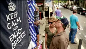  ?? REUTERS ?? Tee shirts are seen on display in a shop in Athens, Greece on Saturday. Greek Prime Minister Alexis Tsipras won backing from lawmakers on Saturday for painful reforms but it remained unclear whether it would be enough to secure a bailout from German...