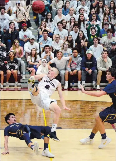  ?? SARAH GORDON/THE DAY ?? East Lyme’s JR Gandenberg­er (2) falls after colliding with Ledyard’s Jack Woodruff (3) while driving to the basket during Thursday’s ECC Division I boys’ basketball showdown at East Lyme. The Colonels won 71-55, handing the Vikings their first loss of...