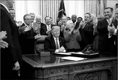  ?? TOM BRENNER / NEW YORK TIMES FILE (2018) ?? President Donald Trump, lawmakers and guests applaud at a signing ceremony for a criminal justice policy bill Dec. 21, 2018, at the White House.