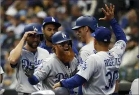  ?? JEFF ROBERSON — THE ASSOCIATED PRESS ?? The Los Angeles Dodgers’ Justin Turner (10) celebrates with teammates and manager Dave Roberts (30) after hitting a two-run home run during the eighth inning of Game 2 of the National League Championsh­ip Series against the Milwaukee Brewers Saturday in Milwaukee.