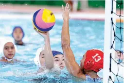  ??  ?? The Philippine­s’ Carla Beatriz Grabador, center, aims for the goal against Thailand’s Khemasiri Sirivejjab­andh, right, during the 1st round robin match of the water polo event in the 30th Southeast Asian Games at the New Clark City in Capas, Tarlac. (AP Photo/Aaron Favila)