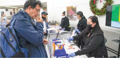  ?? SETH WENIG/AP ?? Passengers disembarki­ng from internatio­nal flights take anonymous COVID tests for study purposes at Newark Liberty Internatio­nal Airport in Newark, N.J., Wednesday. Amid a COVID-19 surge in China, the U.S. is expanding its traveler-based genomic coronaviru­s surveillan­ce program, an early warning system for detecting new variants.