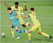  ??  ?? Barcelona’s Argentine forward Lionel Messi (left) challenges Villarreal’s Andre-Frank Zambo Anguissa (right) and Mario Gaspar during their Spanish League football match at the Madrigal Stadium in Villarreal on Sunday. Barcelona won the game 4-1. — AFP