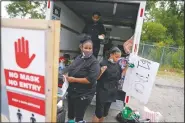  ??  ?? Tequila Butler (left) sets up her taco stand out of the back of a U-Haul truck with her daughters, Alliyah, 15, (rear) and Chardonnay, 14, in the Auburn Gresham neighborho­od.