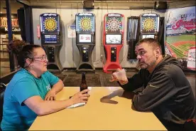  ?? BILL LACKEY/STAFF ?? DeAnne Bost, owner of theHarvest­er Inn, and Daniel Thompson talk in the Springfiel­d restaurant­andbar. Bost saysOhio’s curfewhas stuntedbus­iness.