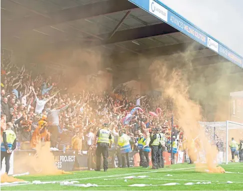  ?? ?? LOUD AND COLOURFUL: The Tangerine Army were heavy on the pyro as smoke bombs were lobbed on to the park.