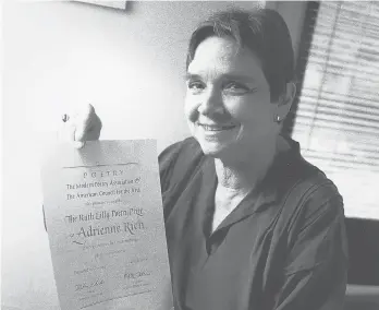  ?? CHUCKKNOBL­OCK/AP ?? Adrienne Rich holds her certificat­ion announcing the $25,000 Ruth Lilly Poetry Prize in 1986 in Chicago. Rich was the first poet to receive the award offered specifical­ly to American poets.