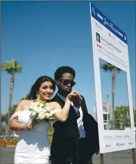 ?? (File Photo/AP/Jae C. Hong) ?? Newlyweds Brenda Zavala (left) and Tray Vann pose for photos May 26, 2020, after their marriage service in the parking lot of Honda Center in Anaheim, Calif.