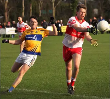  ??  ?? Richard Hughes of Kilanerin with the off-load as Raheen’s Colm Power looks on.