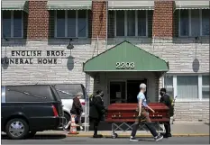  ?? SETH WENIG — THE ASSOCIATED PRESS ?? Pedestrian­s walk past the English Bros Funeral Home as a casket is unloaded in the Brooklyn borough of New York, Sunday, April 19, 2020. New York’s daily toll of coronaviru­s deaths has hit its lowest point in more than two weeks, but officials still warn that New York City and the rest of the state aren’t ready to ease up on shutdowns of schools, businesses and gatherings.