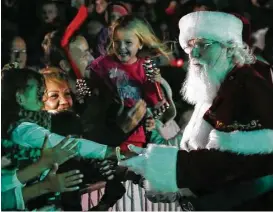 ?? Michael Minasi / Houston Chronicle ?? Santa shakes hands with fans during the Lighting of the Doves event on Nov. 18, at Town Green Park.