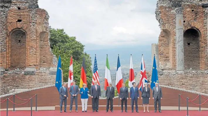  ?? DPA ?? Todos juntos. Los presidente­s del Consejo Europeo y de la Comisión Europea flanquean a los siete líderes de las naciones miembros del G-7, con el fondo paradisíac­o de Taormina.