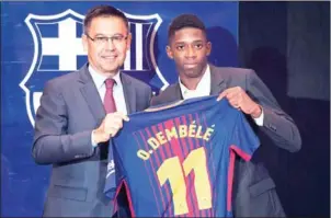  ?? LLUIS GENE/AFP ?? Ousmane Dembele (right) poses with his jersey next to Barcelona President Josep Maria Bartomeu at the Camp Nou stadium in Barcelona on Monday.