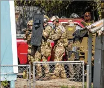  ??  ?? Heavily armed FBI agents approach the home of Mark Conditt, the Austin bombing suspect, in Pflugervil­le, Texas, on Wednesday. Conditt lived in the house along with two roommates.