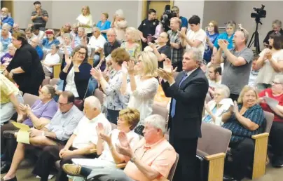  ?? STAFF PHOTO BY TIM BARBER ?? East Ridge residents applaud the vote at Monday morning’s special city council meeting where the council voted to abolish the developmen­t committee formed by Mayor Brent Lambert.